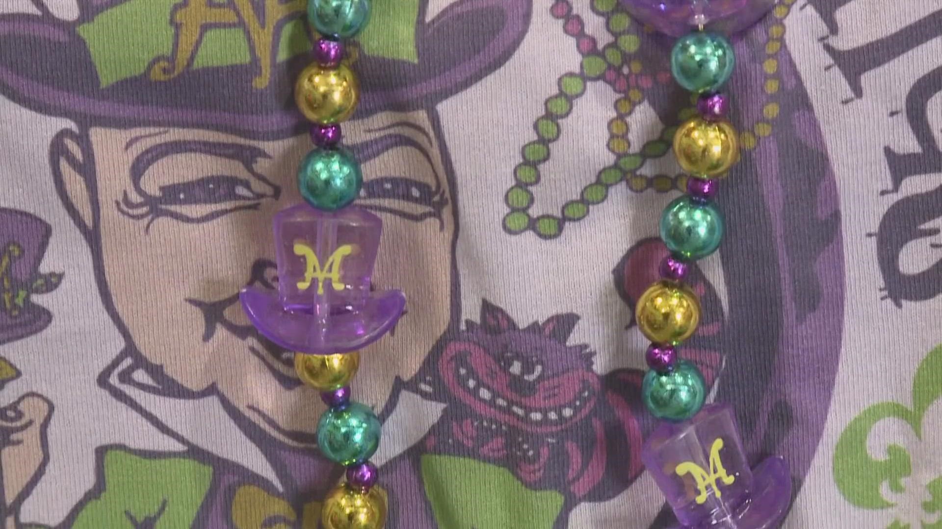 Leslie Spoon is in the Krewe of Mad Hatters den checking out some of their unique throws.