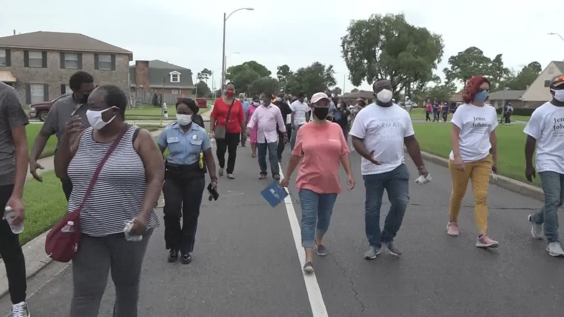 Shoulder to shoulder the group marched through the neighborhood to a local park, some chanting as others held signs.