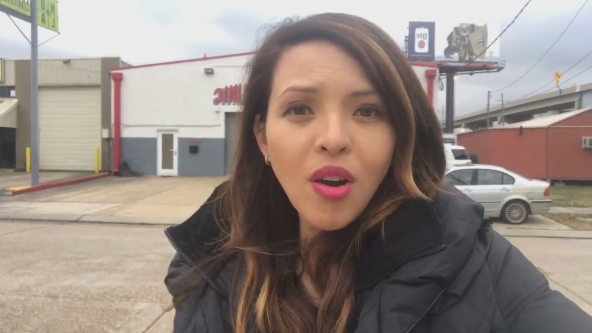 WWL-TV reporter Jacqueline Quynh shows the scene where a car fell off the side of a two-story parking garage in Jefferson Parish.
