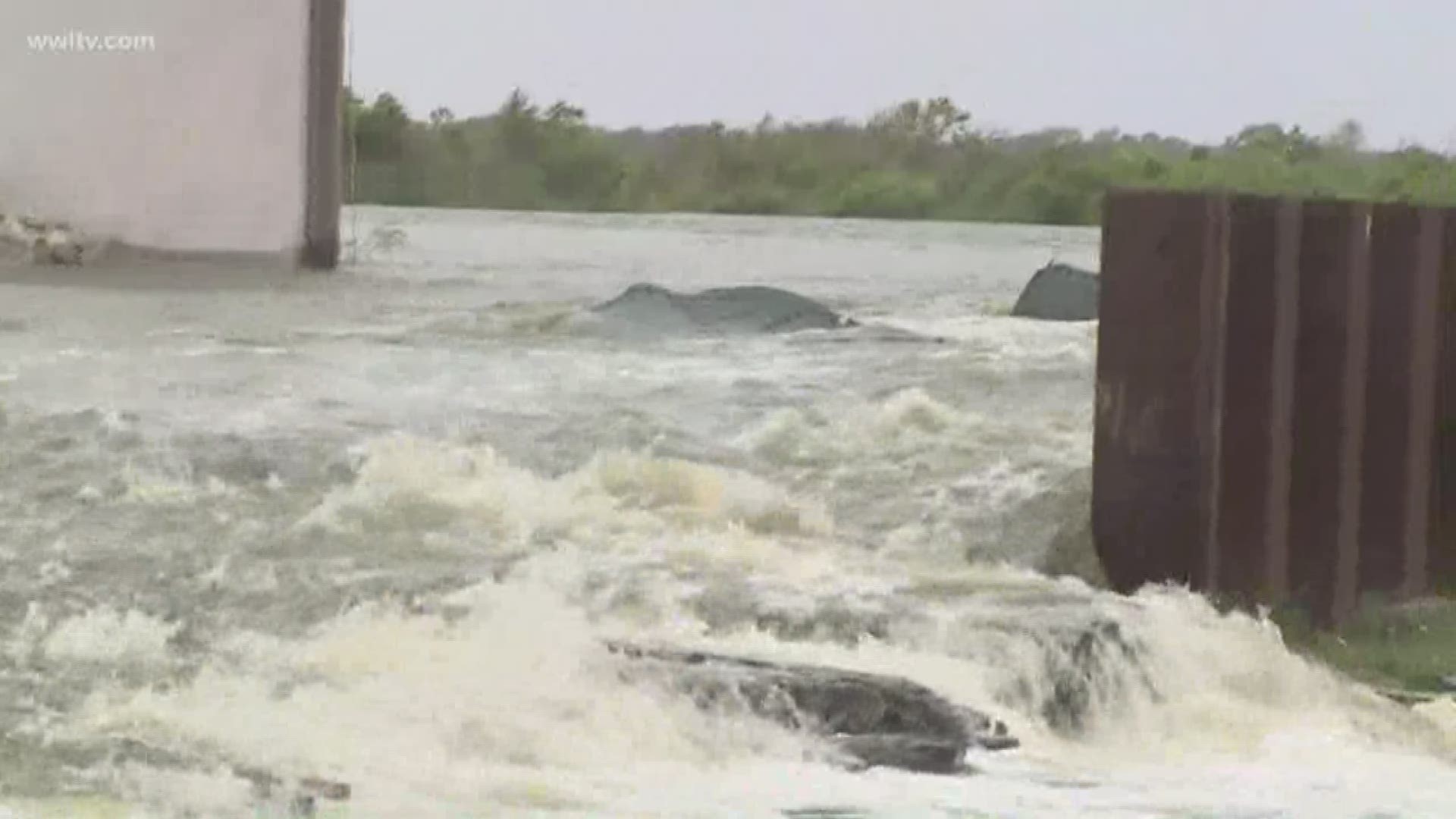 Water is rushing over a back levee that protects areas of Plaquemines Parish. There appear to be two gaps