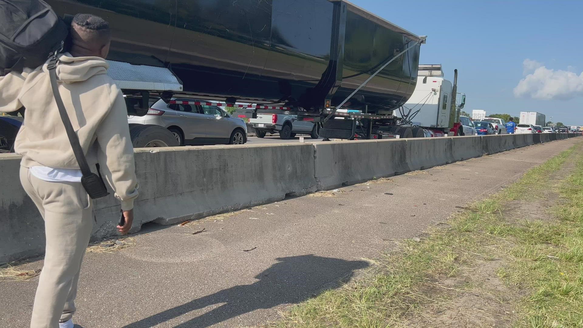 With traffic at a standstill on I-10 west before the airport exit, some travelers decided to walk alongside the interstate to hopefully make their scheduled flights.
