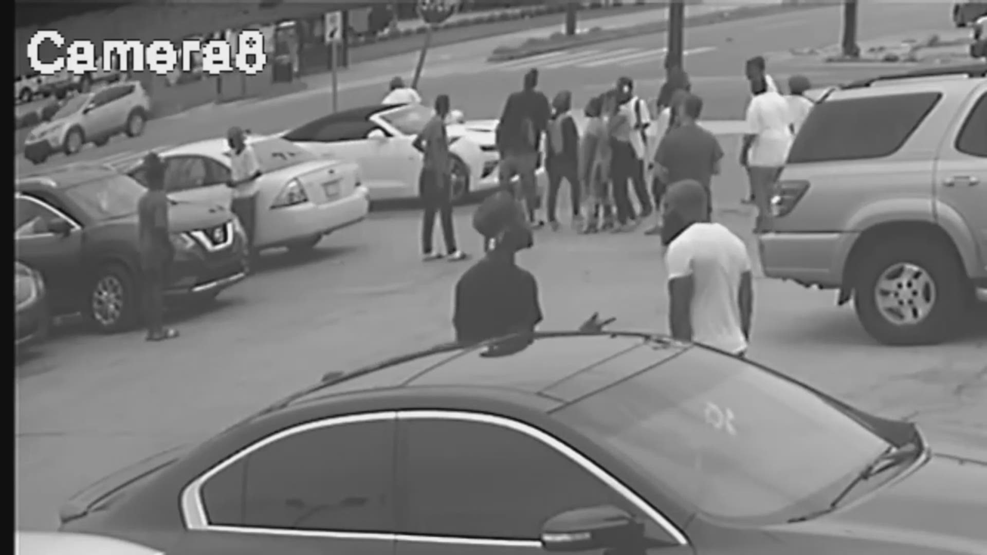 The video shows an unidentified suspect run into a crowd of people and fire several shots from a rifle.