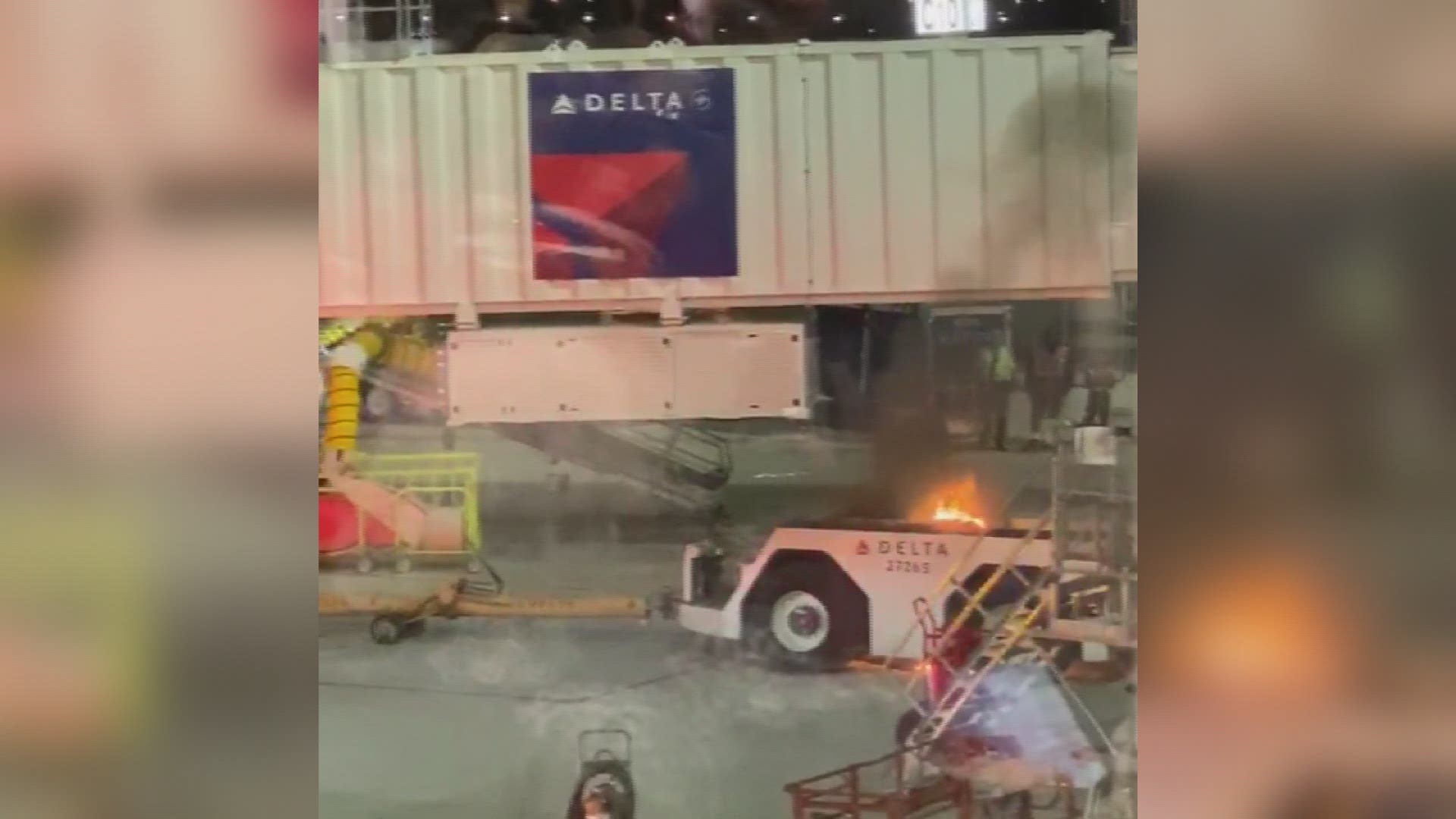 Footage shows a Delta Air Lines vehicle on fire underneath a terminal bridge.