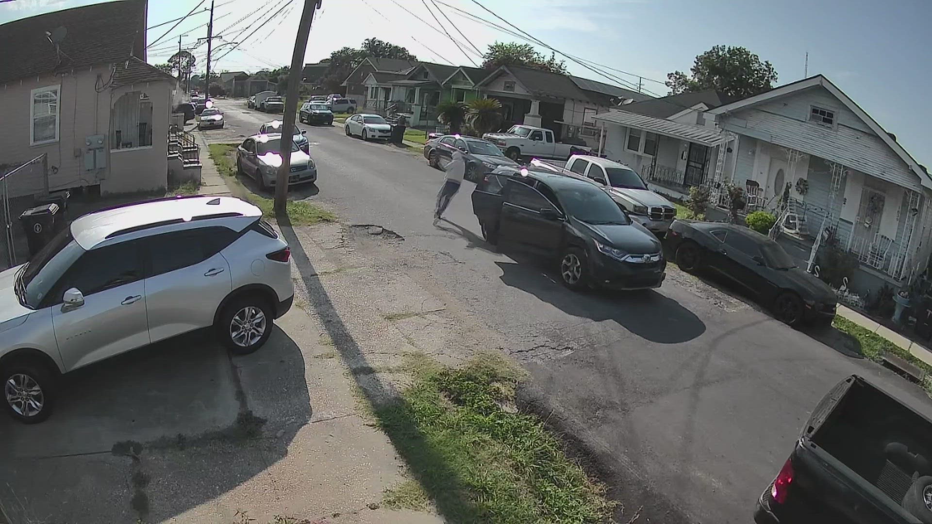 Two people hop out of the car and continue firing toward a home. The video also shows someone on the porch of the home returning fire.