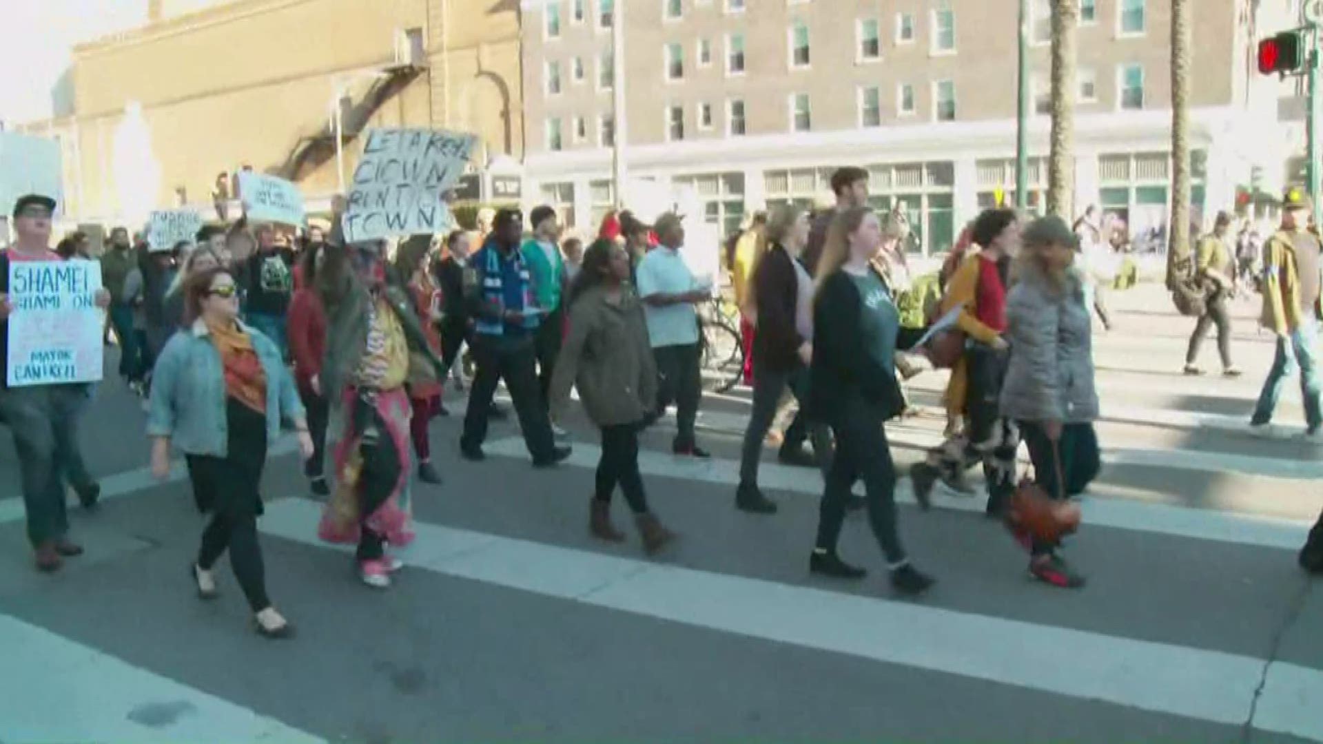 A few hundred protesters made the short walk while chanting to take the site down. Some held signs, some dressed as clowns.