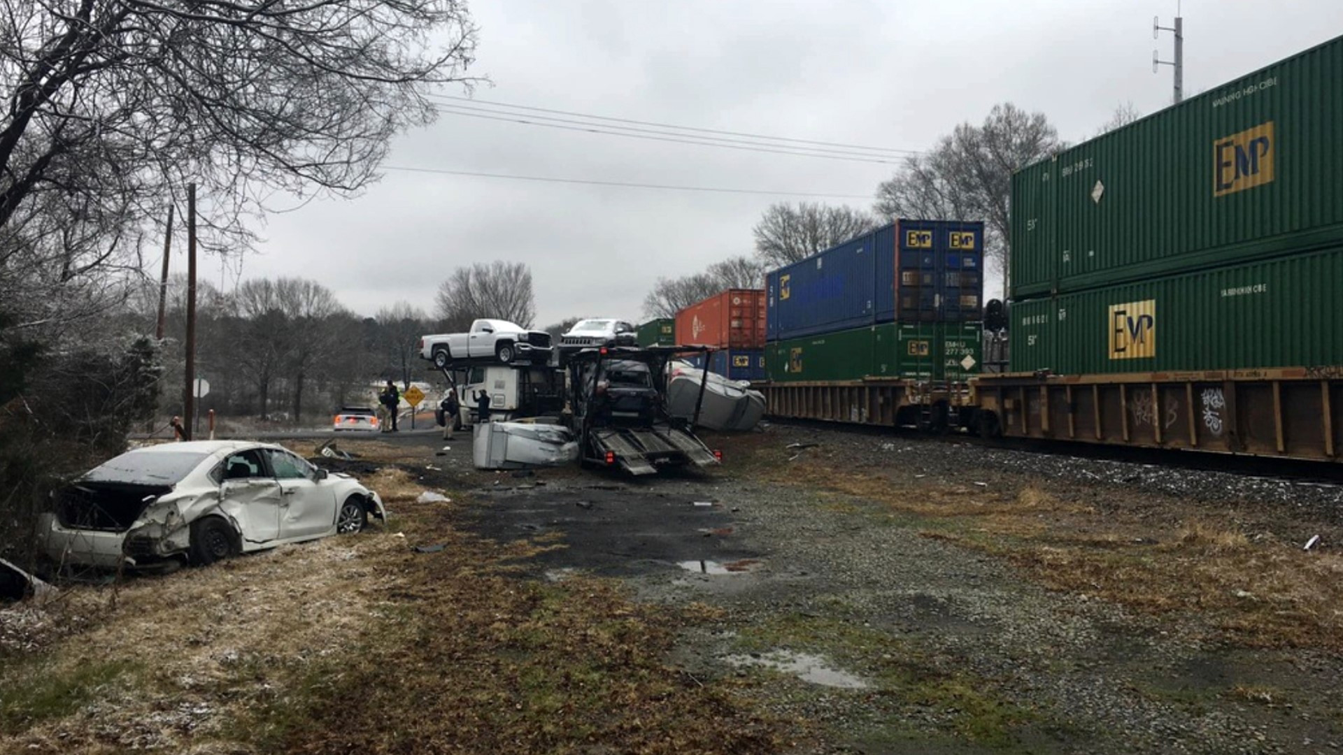 Train hits car carrier; 2 crew members hurt, highway closed